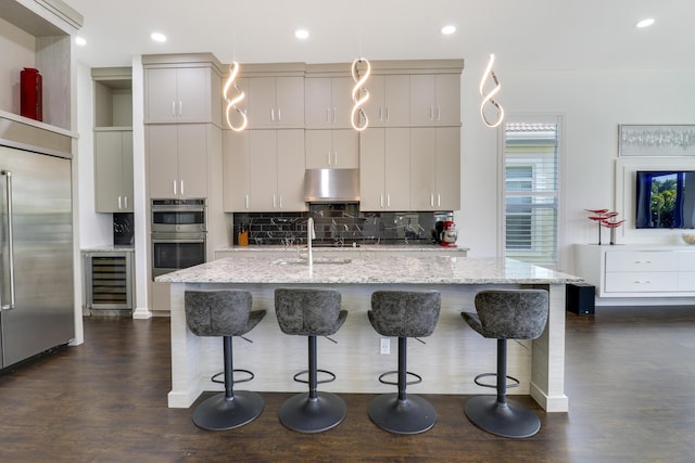 kitchen featuring appliances with stainless steel finishes, a breakfast bar, sink, and a center island with sink