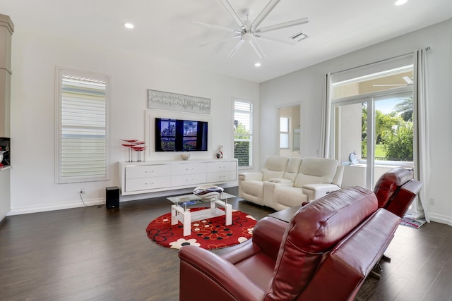 living room with dark wood-type flooring, a wealth of natural light, and ceiling fan