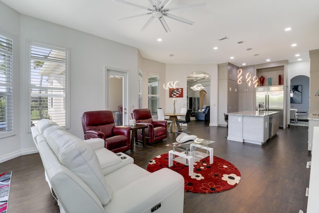 living room with dark wood-type flooring and ceiling fan