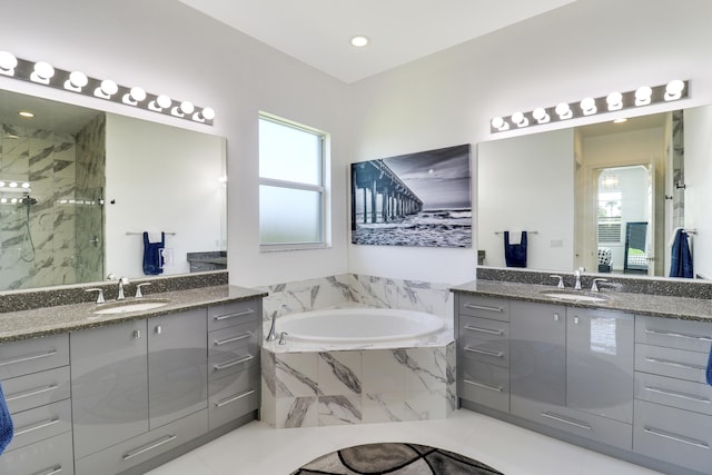 bathroom with vanity and shower with separate bathtub