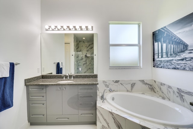 bathroom featuring vanity and independent shower and bath