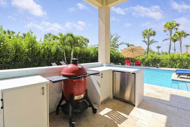 view of patio / terrace featuring a fenced in pool, a grill, and an outdoor bar