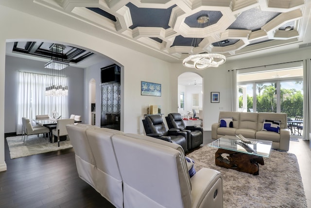 living room with crown molding, coffered ceiling, dark hardwood / wood-style floors, and a chandelier