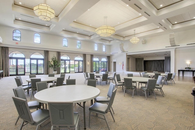 dining area with a high ceiling, coffered ceiling, and light colored carpet