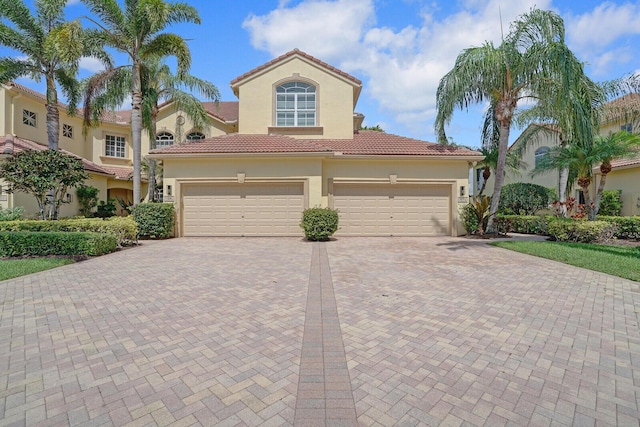 7575 Orchid Hammock Dr, West Palm Beach, FL 33412 - mediterranean / spanish-style home with decorative driveway, stucco siding, an attached garage, and a tiled roof