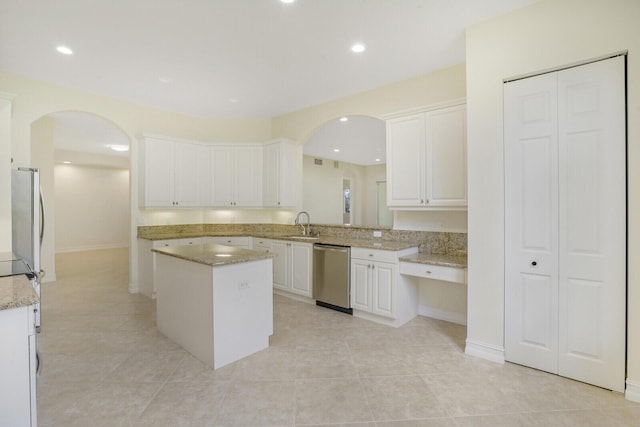 7575 Orchid Hammock Dr, West Palm Beach, FL 33412 - kitchen with appliances with stainless steel finishes, arched walkways, a center island, white cabinets, and recessed lighting
