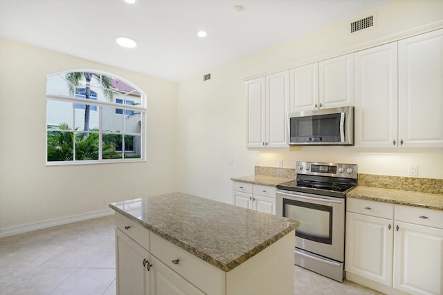7575 Orchid Hammock Dr, West Palm Beach, FL 33412 - kitchen with stainless steel appliances, light stone counters, a kitchen island, baseboards, and recessed lighting