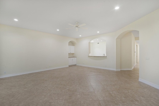 unfurnished living room featuring light tile patterned floors and ceiling fan