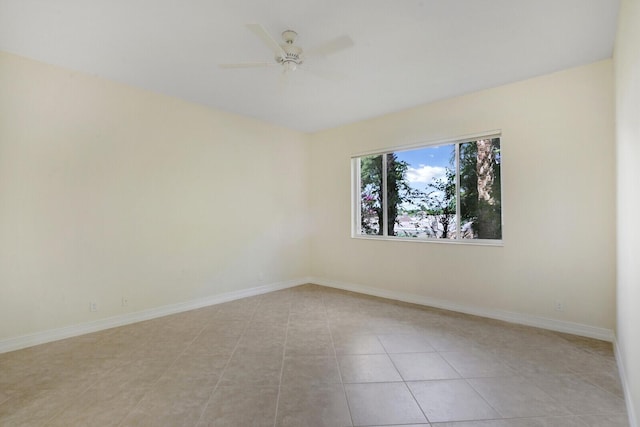 empty room with ceiling fan and light tile patterned floors