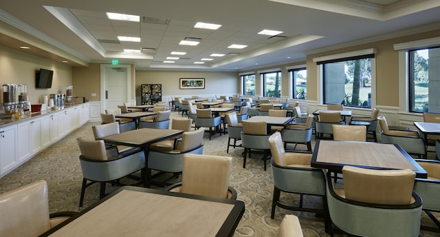 dining area featuring a tray ceiling, a healthy amount of sunlight, and ornamental molding