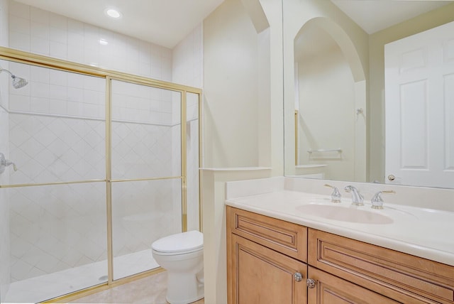 bathroom with tile patterned flooring, vanity, toilet, and a shower with shower door