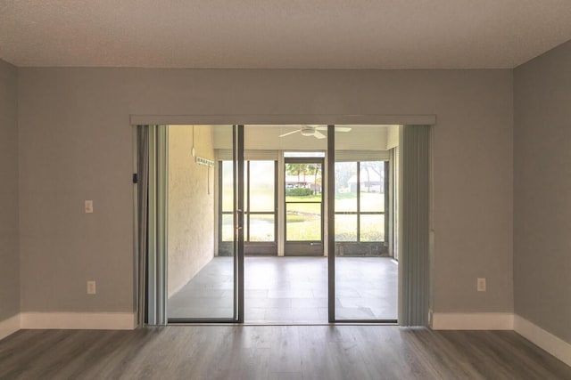 unfurnished room featuring hardwood / wood-style floors, ceiling fan, and a textured ceiling