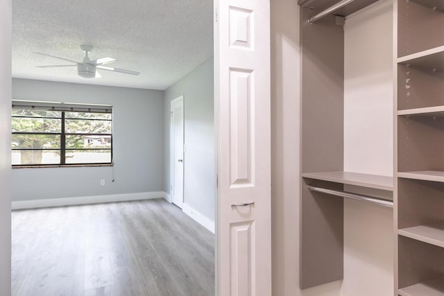 walk in closet with light hardwood / wood-style flooring and ceiling fan