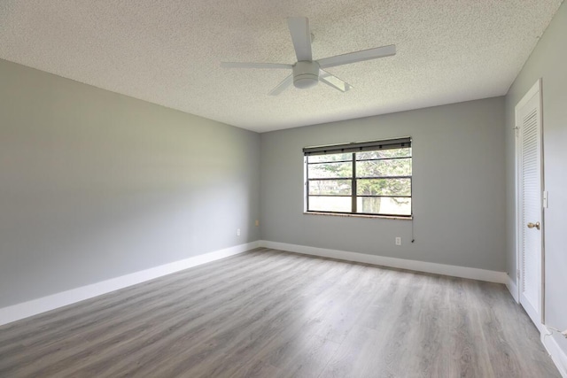 spare room featuring ceiling fan, light hardwood / wood-style floors, and a textured ceiling