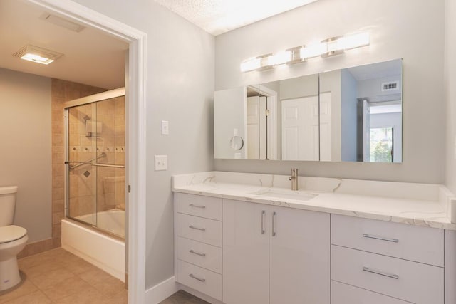 full bathroom featuring shower / bath combination with glass door, tile patterned floors, vanity, and toilet