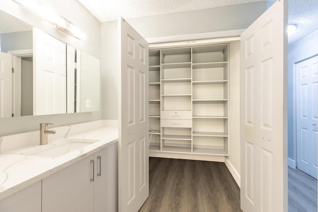 bathroom with hardwood / wood-style floors, vanity, and a textured ceiling