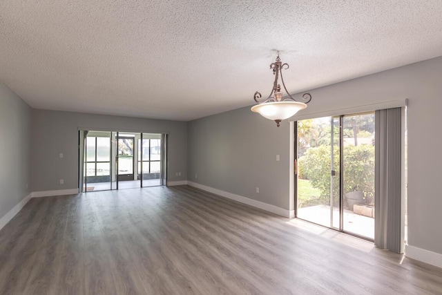 spare room featuring hardwood / wood-style floors and a textured ceiling