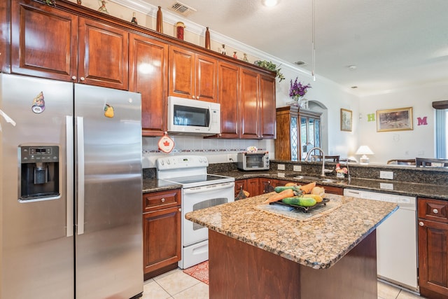 kitchen featuring sink, white appliances, stone countertops, and light tile floors