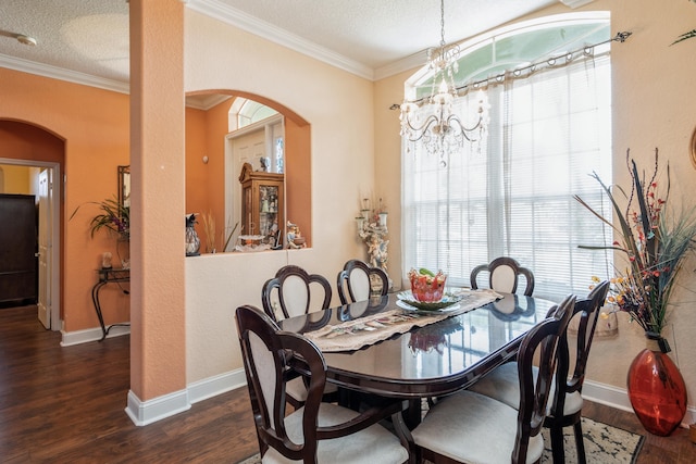 dining space featuring an inviting chandelier, a textured ceiling, dark hardwood / wood-style floors, and crown molding