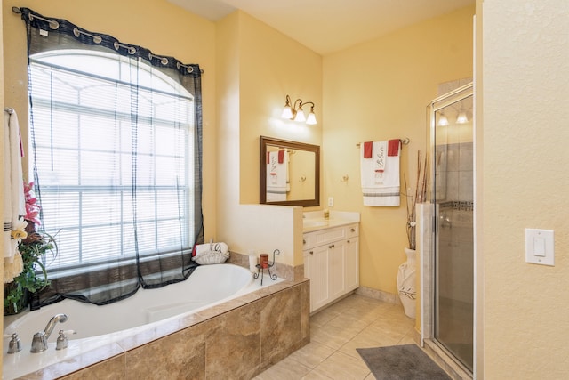 bathroom with tile floors, vanity, and shower with separate bathtub