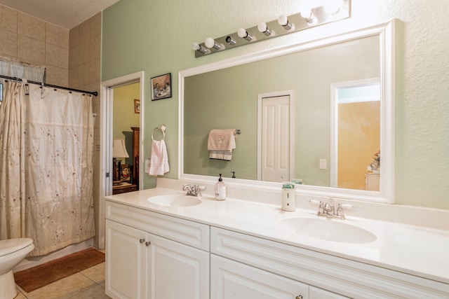 bathroom with tile flooring, vanity with extensive cabinet space, toilet, and double sink