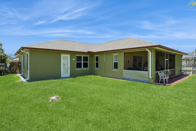 rear view of property with a sunroom and a lawn