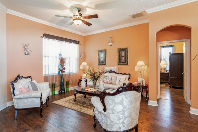 living room with ornamental molding, dark hardwood / wood-style floors, ceiling fan, and a textured ceiling