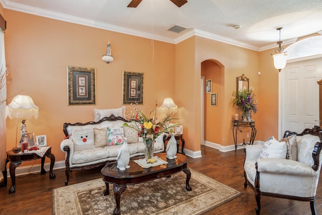 living room with dark hardwood / wood-style flooring, ceiling fan, a textured ceiling, and crown molding