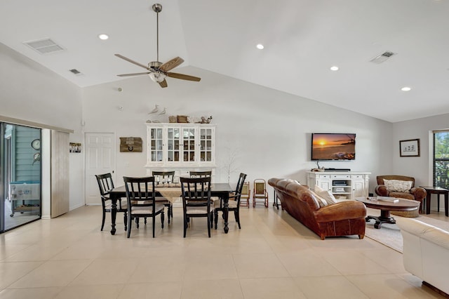 dining space featuring ceiling fan, light tile patterned floors, and vaulted ceiling