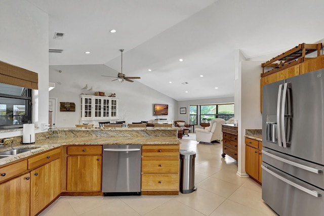 kitchen with ceiling fan, vaulted ceiling, kitchen peninsula, stainless steel fridge with ice dispenser, and light stone counters