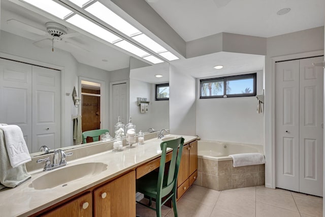 bathroom with ceiling fan, tile patterned floors, vanity, and a relaxing tiled tub