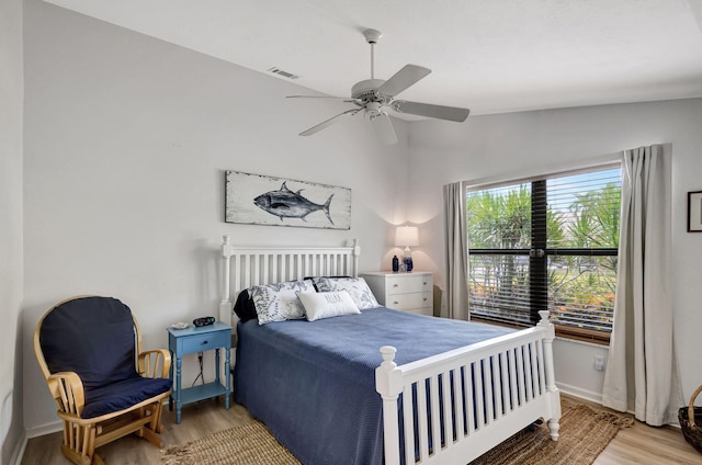 bedroom featuring ceiling fan, light wood-type flooring, and vaulted ceiling