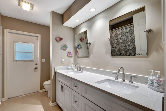 bathroom featuring tile patterned floors, toilet, vanity, and walk in shower