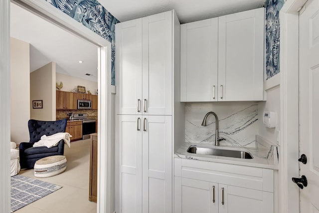 bar featuring white cabinetry and stainless steel appliances