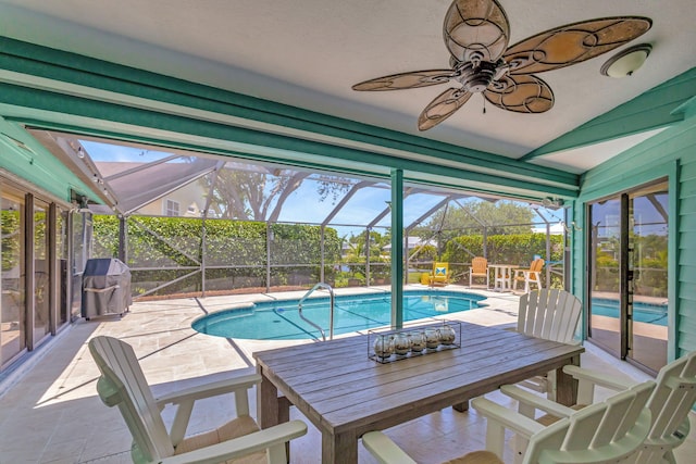 view of swimming pool with ceiling fan, a patio area, glass enclosure, and area for grilling