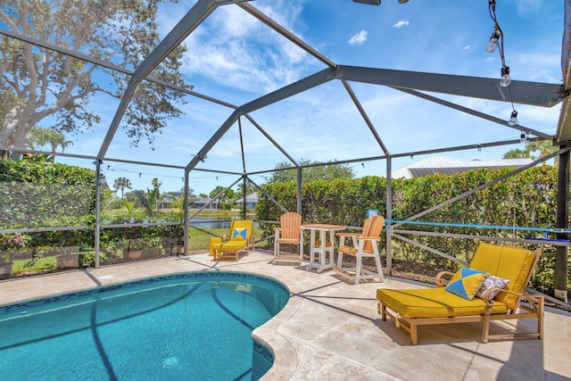 view of pool featuring glass enclosure and a patio