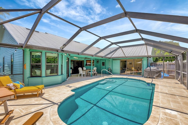 view of swimming pool featuring a patio area and a lanai