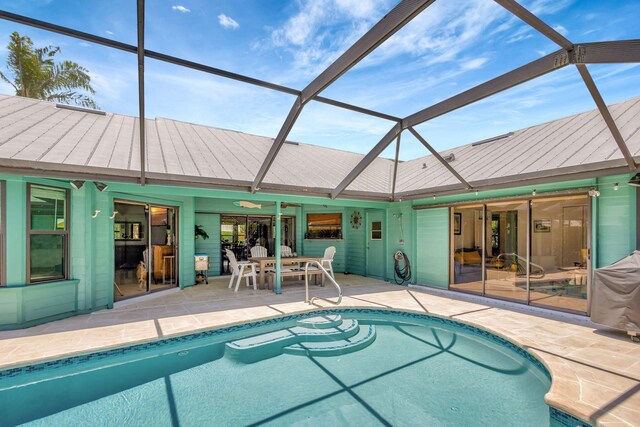 view of swimming pool with glass enclosure, a patio area, and ceiling fan