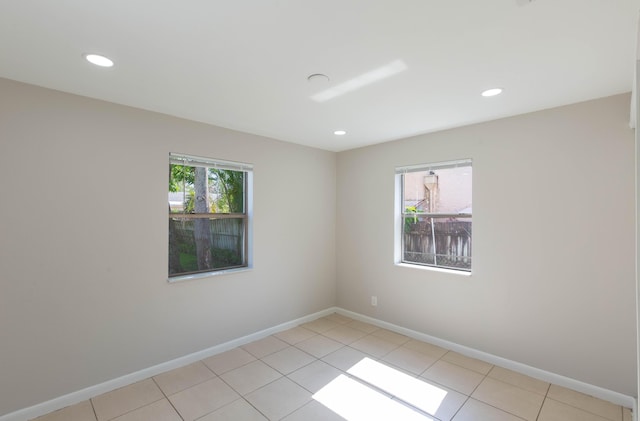 empty room with a healthy amount of sunlight and light tile patterned flooring