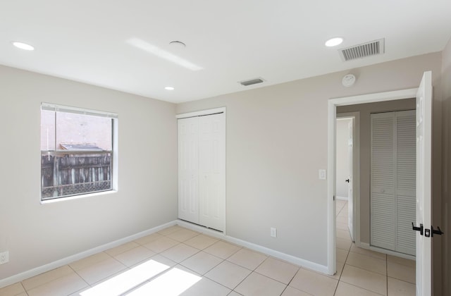 unfurnished bedroom featuring light tile patterned floors and a closet