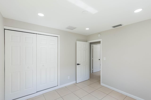 unfurnished bedroom with light tile patterned floors and a closet