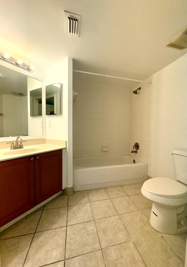 full bathroom with vanity, tiled shower / bath combo, tile patterned floors, and toilet