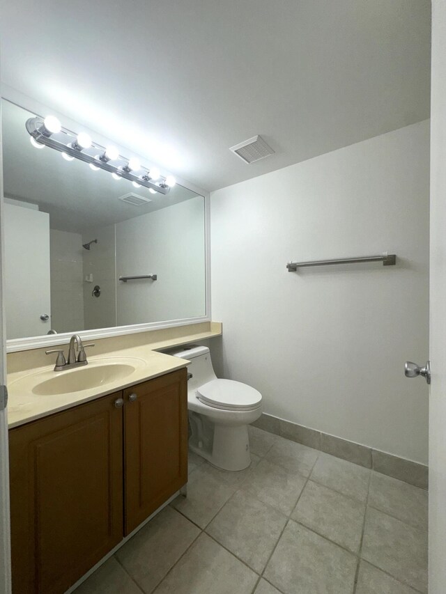 bathroom with vanity, a shower, tile patterned floors, and toilet