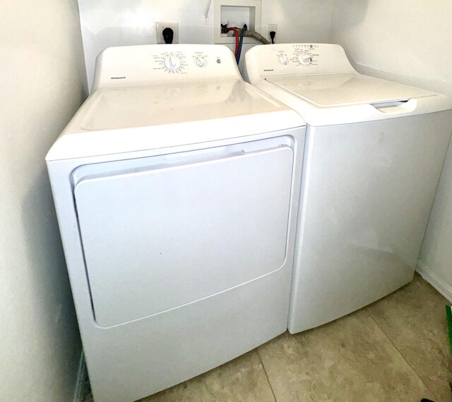 washroom featuring washer and clothes dryer and light tile patterned floors