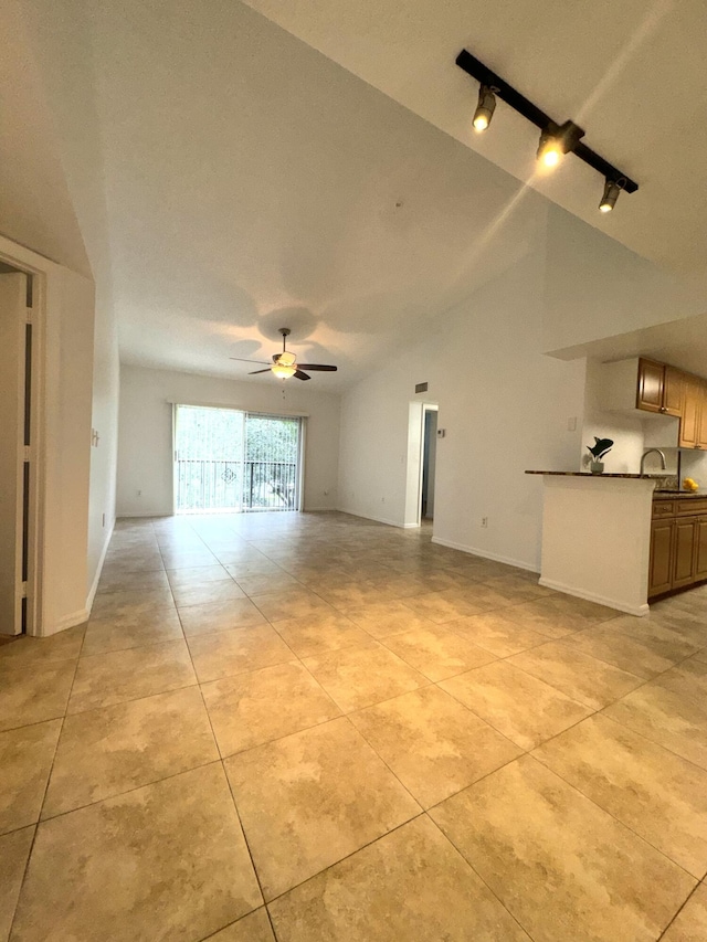 unfurnished living room featuring track lighting, light tile patterned floors, ceiling fan, and vaulted ceiling