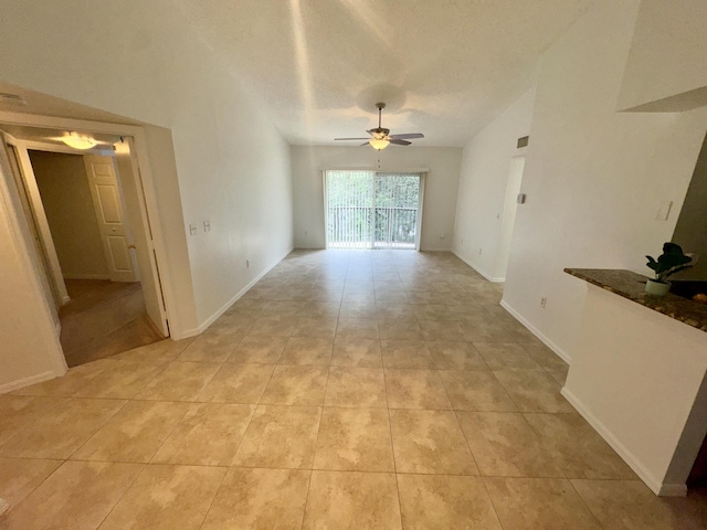 unfurnished living room with ceiling fan, light tile patterned flooring, and a textured ceiling