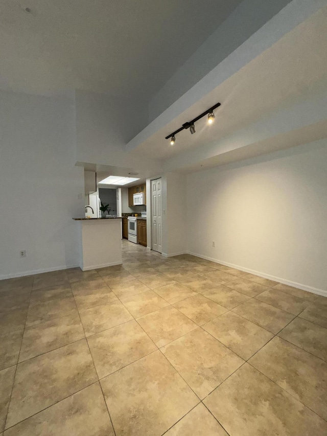 unfurnished living room with track lighting and light tile patterned floors