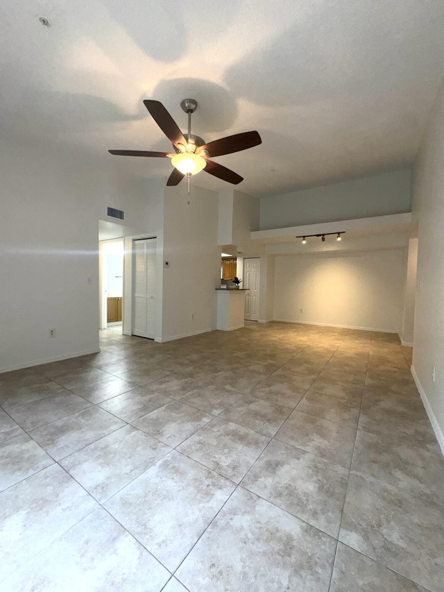 unfurnished living room with vaulted ceiling, light tile patterned floors, a textured ceiling, and ceiling fan