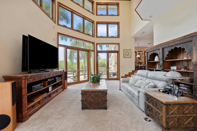 carpeted living room featuring french doors and a high ceiling