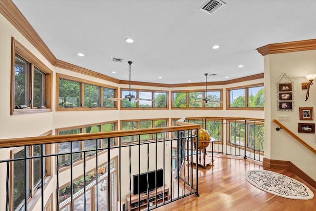 hall with light hardwood / wood-style floors and ornamental molding